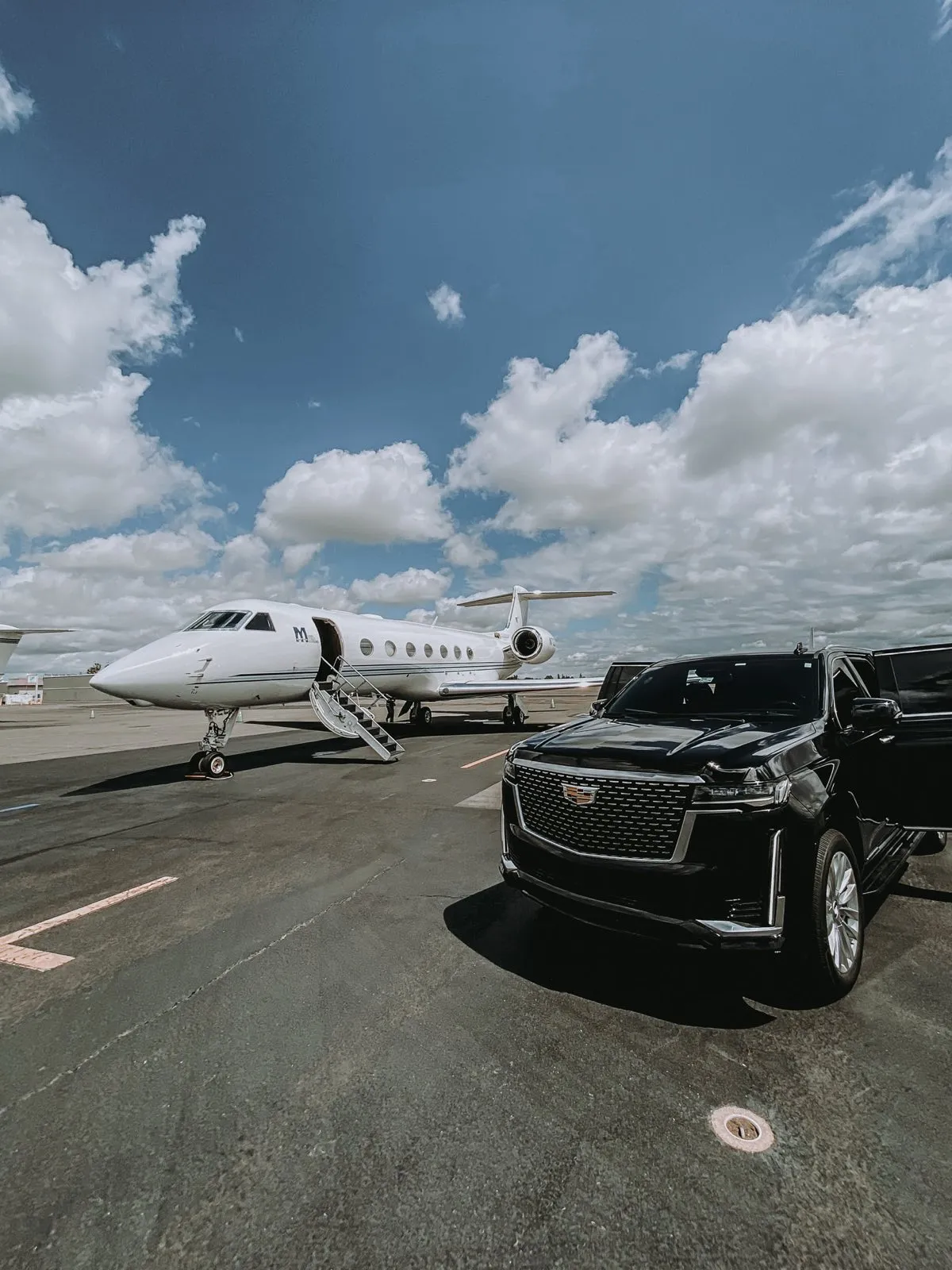 SacRoyale Cadillac Escalade meeting a private jet on the tarmac
